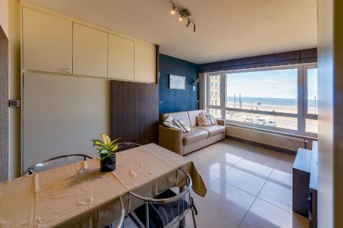 a living room with a table and a view of the ocean at Splendid Seaview - Ostend Luxury Studio 4 persons at beach and sea in Ostend