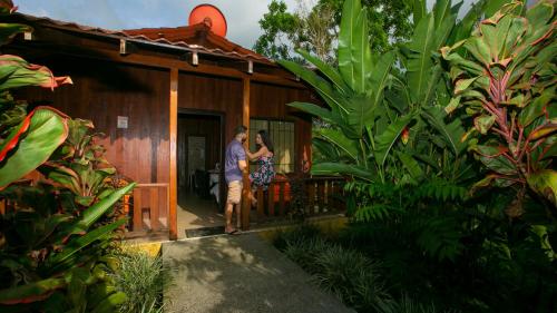 een man en een vrouw die buiten een huis staan bij Hotel Rancho Cerro Azul in Fortuna