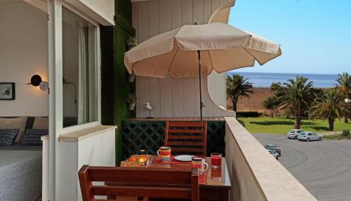 a table with an umbrella on a balcony at Studio At The Beach in Alvor