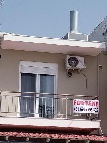 a for rent sign on a balcony of a house at Katerina apartment in Nea Plagia