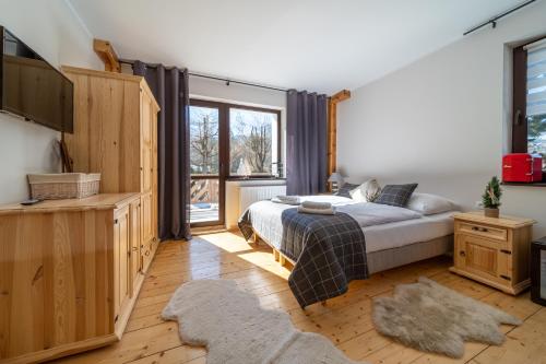 um quarto com uma cama e uma grande janela em Skalna Rezydencja em Karpacz