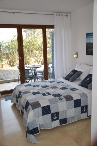 Apartment Relax Villa Salena في سلاتين: غرفة نوم بسرير وطاولة مع كراسي