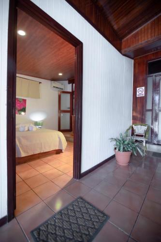 a bedroom with a bed and a door leading into a room at Hotel El Jardin in Montezuma