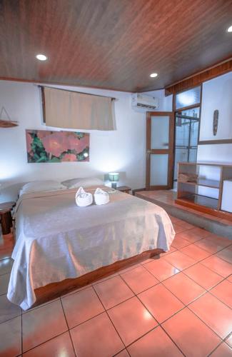 a bedroom with a bed with two shoes on it at Hotel El Jardin in Montezuma