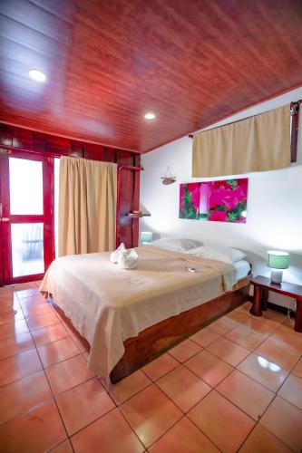 a bedroom with a large bed in a room at Hotel El Jardin in Montezuma