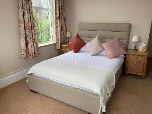 a bedroom with a bed with pillows and a window at Dolphin Hotel in Bovey Tracey