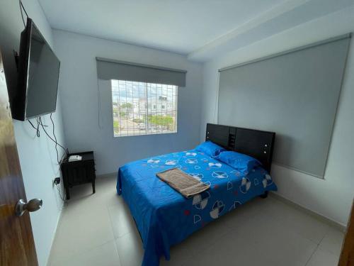 a bedroom with a blue bed and a television at Apto Completo Monteria, cómodo con Wifi y SmarTV in Montería