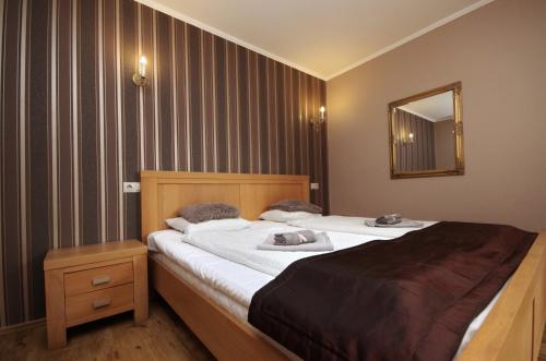 a bedroom with a large bed and a mirror at Guest House Romantika Panzio in Gyula