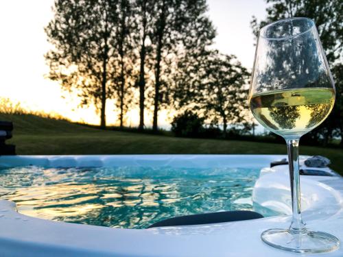 a glass of wine sitting next to a hot tub at Sydkustens at Pillehill in Skivarp