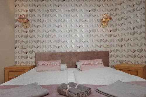 a bedroom with a bed with pink pillows at Guest House Romantika Panzio in Gyula