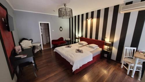 a bedroom with a bed and a table and a chair at Guest House Romantika Panzio in Gyula