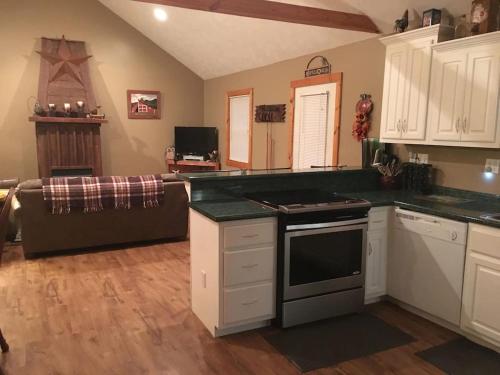 a kitchen with white cabinets and a stove top oven at Gas fireplace, firepit, and cedar Adirondack chair in Spencer