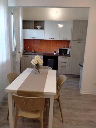 a kitchen with a table with a vase of flowers on it at Sea&Bike_Apartment in Finale Ligure