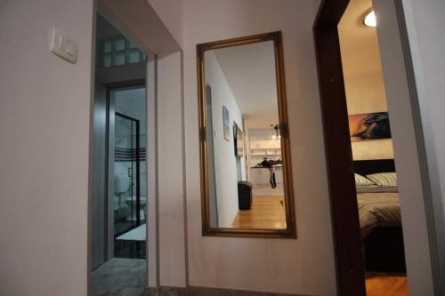 a mirror on a wall next to a bedroom at Moderan apartman u blizini mora in Povile