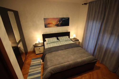 a bedroom with a large bed and two night stands at Moderan apartman u blizini mora in Povile