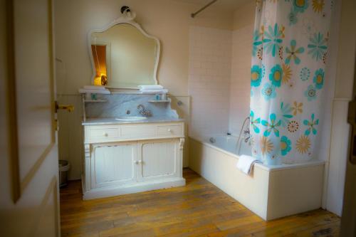 Oranje City Hotel في دييست: حمام مع حوض وحوض ومرآة