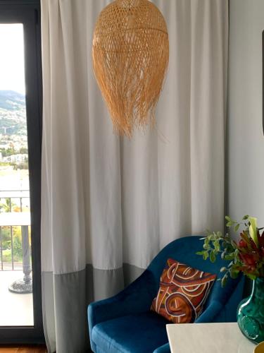 a living room with a blue chair and a basket at Belvedere Boutique - Adults only in Funchal