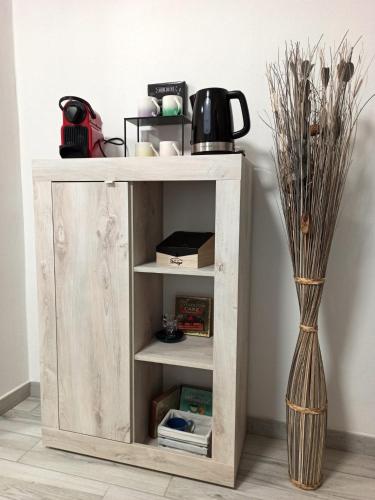 a wooden cabinet with shelves next to a vase at LA CASA DI FRANCESCO in Putifigari