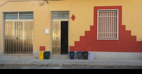a building with doors and trash cans in front of it at Casa vacanze da Giusy Sicilia bedda Avola in Avola