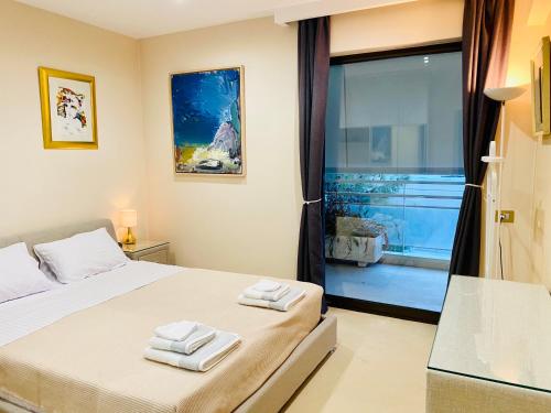 a bedroom with a bed with towels on it at Villasonboard Vouliagmeni Penthouse Veranda Sea-view & beach in Athens