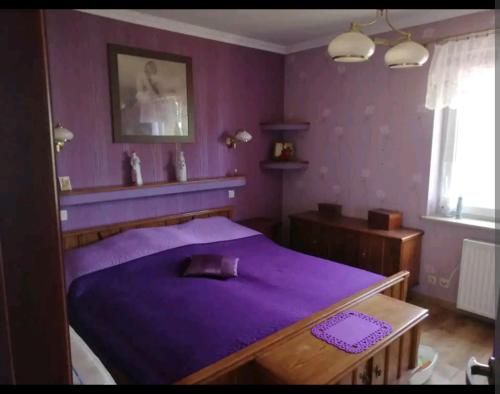 a purple bedroom with a bed with a purple blanket at Apartament w domu z kominkiem i ogrodem in Reda