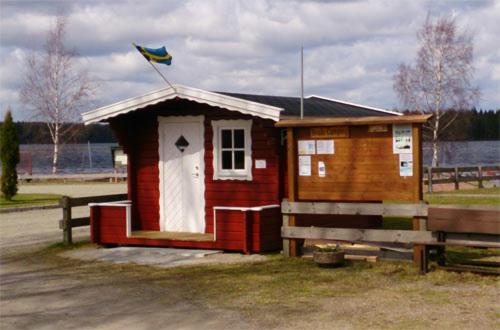 ein kleines Haus mit einer Flagge darüber in der Unterkunft Braås camping in Braås