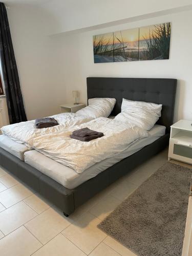 a large bed with a black frame in a bedroom at In der Luft Obergeschoss in Wesel