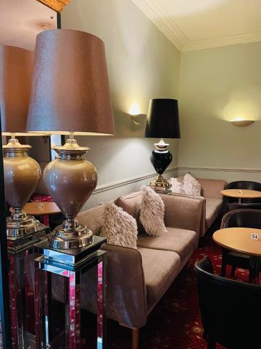 a living room with a couch and a lamp at Merrion Hotel in Llandudno