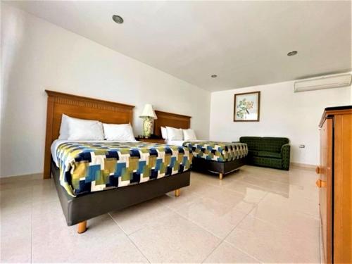 a bedroom with a bed and a couch in it at Hotel Embajadores in Mérida
