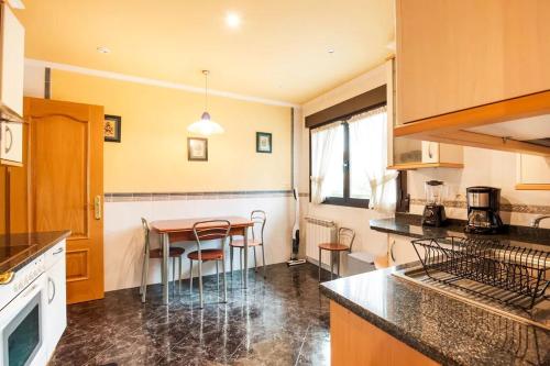 a kitchen with a table and chairs in it at Magnífica casa con jardin, BBQ e hidromasaje in Leitza