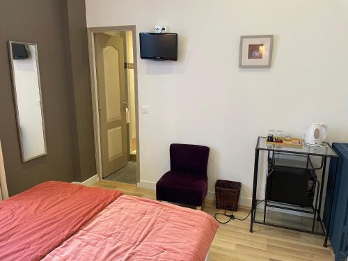 a bedroom with a bed and a desk and a chair at Hôtel La Villa Patricia - Charme et Tradition in Villefranche-sur-Mer