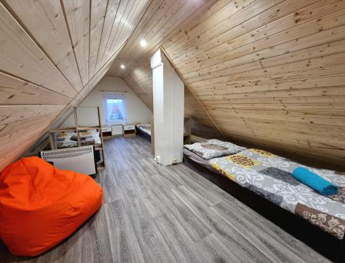 an attic bedroom with two beds and a wooden ceiling at Ubytování BOBULKA Bulhary in Bulhary