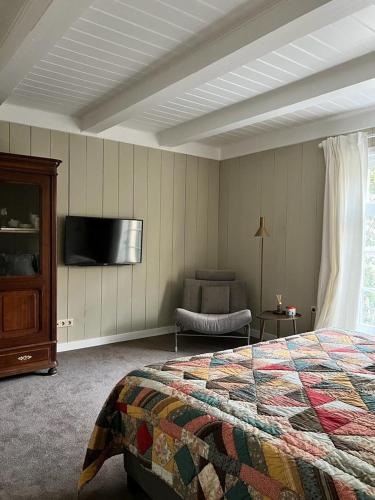 a bedroom with a bed and a flat screen tv at Dahli's Sleep Boutique in Amsterdam