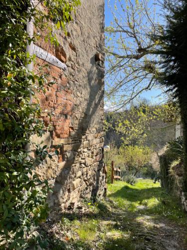 a brick wall with a shadow on the side of it at Orbregno Country Houses with Personal Wine Cellar in Prasco