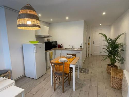 une cuisine avec une table et un réfrigérateur blanc dans l'établissement Joli gîte à Chéroy, à Chéroy