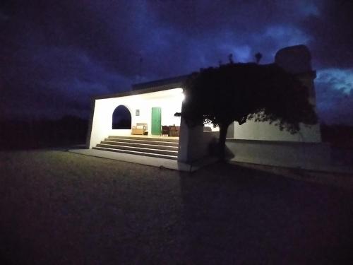 a white building with a staircase in the dark at Abaton - Casa vacanza in Metaponto