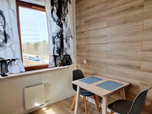 ein kleiner Tisch und Stühle in einem Zimmer mit Fenster in der Unterkunft visit baltic - Apartament skandynawski Platan in Świnoujście