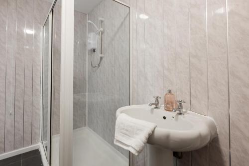 een witte badkamer met een wastafel en een douche bij RST Stanley Park in Liverpool