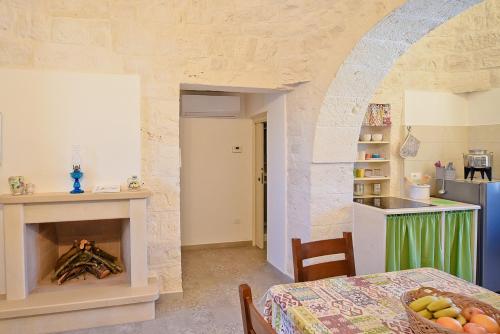 - une cuisine avec une table et une cheminée dans la chambre dans l'établissement Pietra d'angolo, à Locorotondo