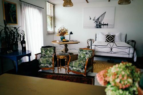 uma sala de estar com uma cama e duas cadeiras e uma mesa em Converted Barn - Tiger House Hermitage em Havelock North