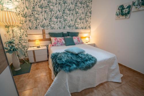 Un pequeño dormitorio con una cama con una manta azul. en Ke Casetta Tenerife, en Costa del Silencio