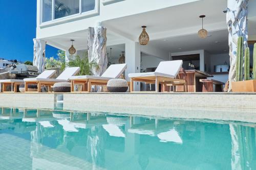 a group of chairs sitting next to a swimming pool at Casa Roni - 5 Bedroom Luxury Villa with Ocean View in Playa Estacahuite