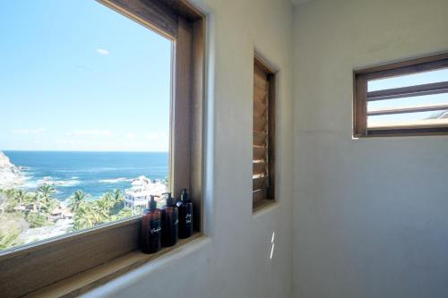 a window with bottles of wine on a wall at Casa Roni by Xeno - 5 Bedroom Luxury Villa with Ocean View in Playa Estacahuite