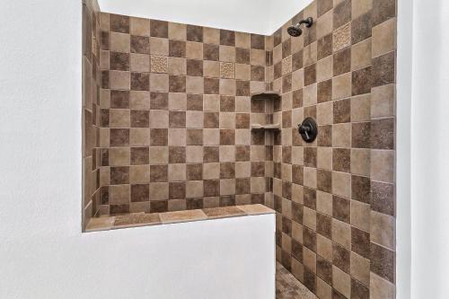 a bathroom with a shower with brown tiles at Spacious Murphy Cabin with Game Rooms and Mtn Views! in Murphy