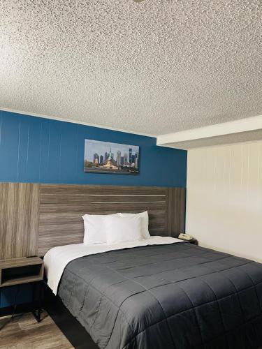 a bedroom with a large bed with a blue wall at Crown Inn in Linden