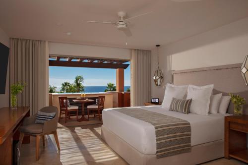 een slaapkamer met een groot bed en een eetkamer bij Zoetry Casa del Mar Los Cabos in Cabo San Lucas