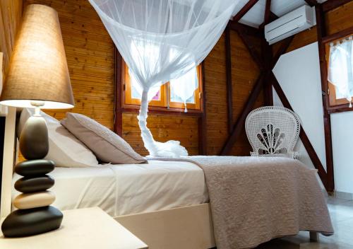 een slaapkamer met een wit bed en een lamp bij La Savannah Villa in Labuthie