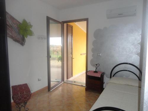 a room with a mirror and a bed and a chair at Agriturismo Gavina Pes in Campanedda