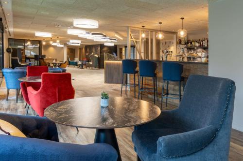 a lobby with chairs and a table and a bar at Best Western Plus Le Conquerant Rouen Nord in Bois-Guillaume
