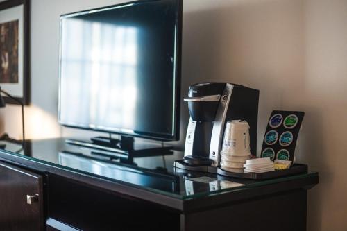 a desk with a coffee maker and a tv at Ramada by Wyndham Surrey/Langley in Surrey